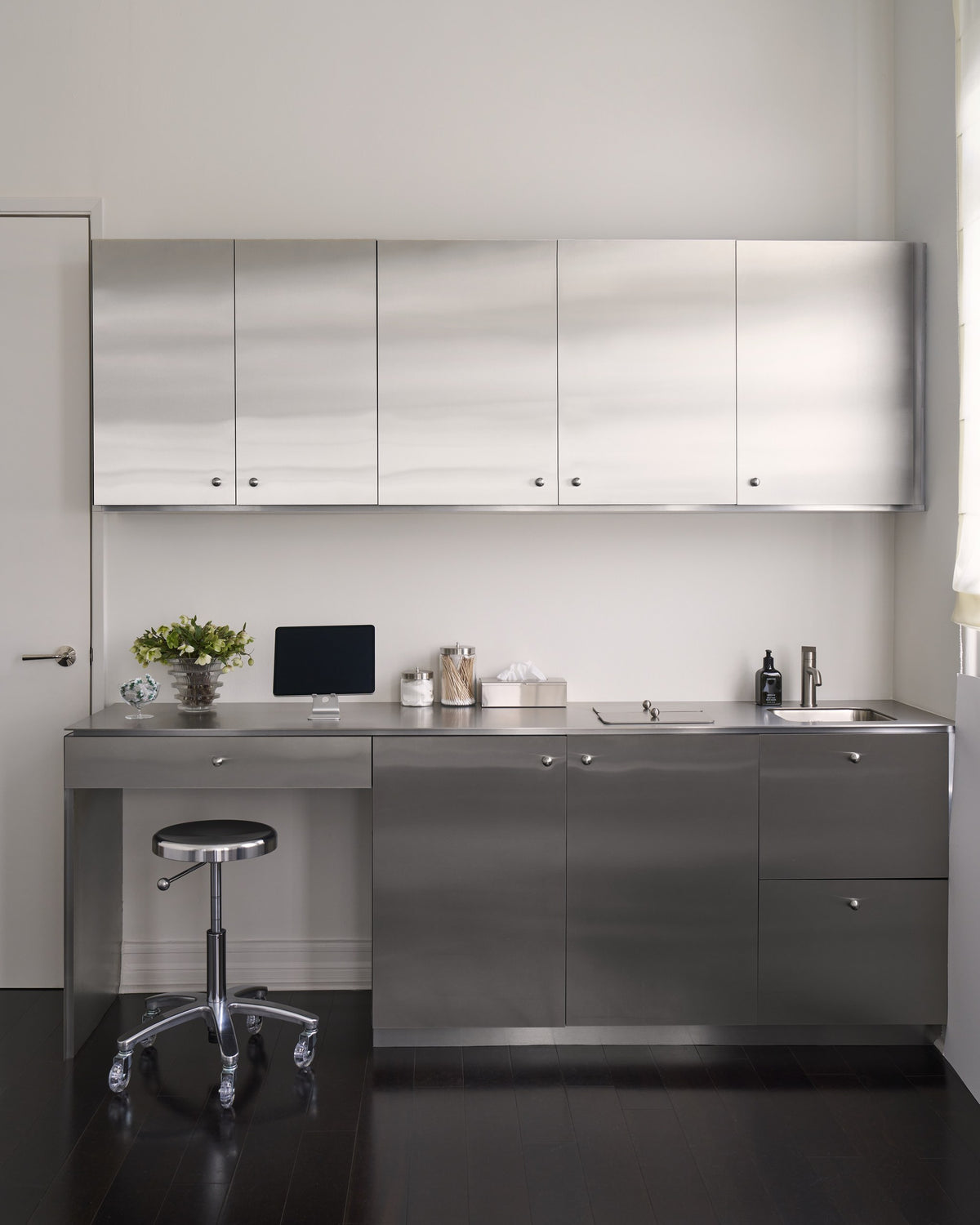 Stainless steel treatment room at the Contrapposto clinic with counter, stool and sink
